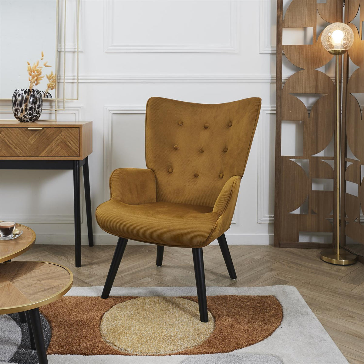 Fauteuil à oreilles capitonné en velours jaune moutarde pieds noirs